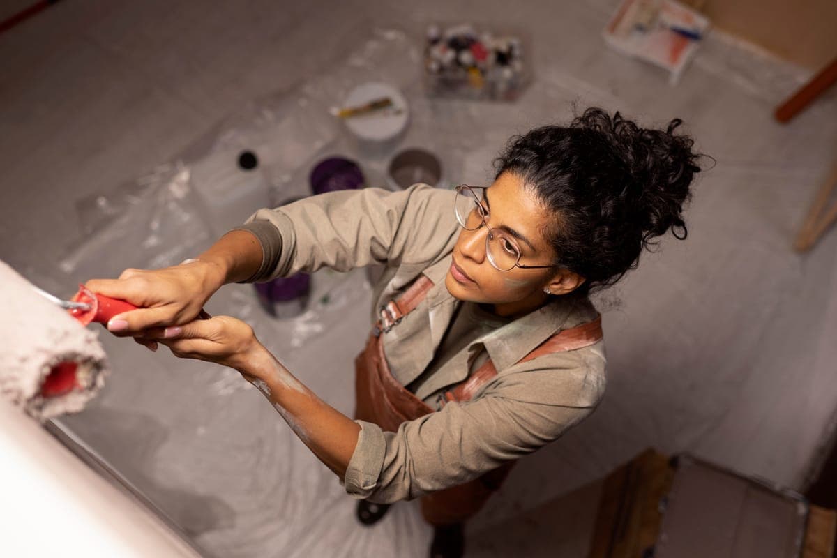 A handyworker painting a wall